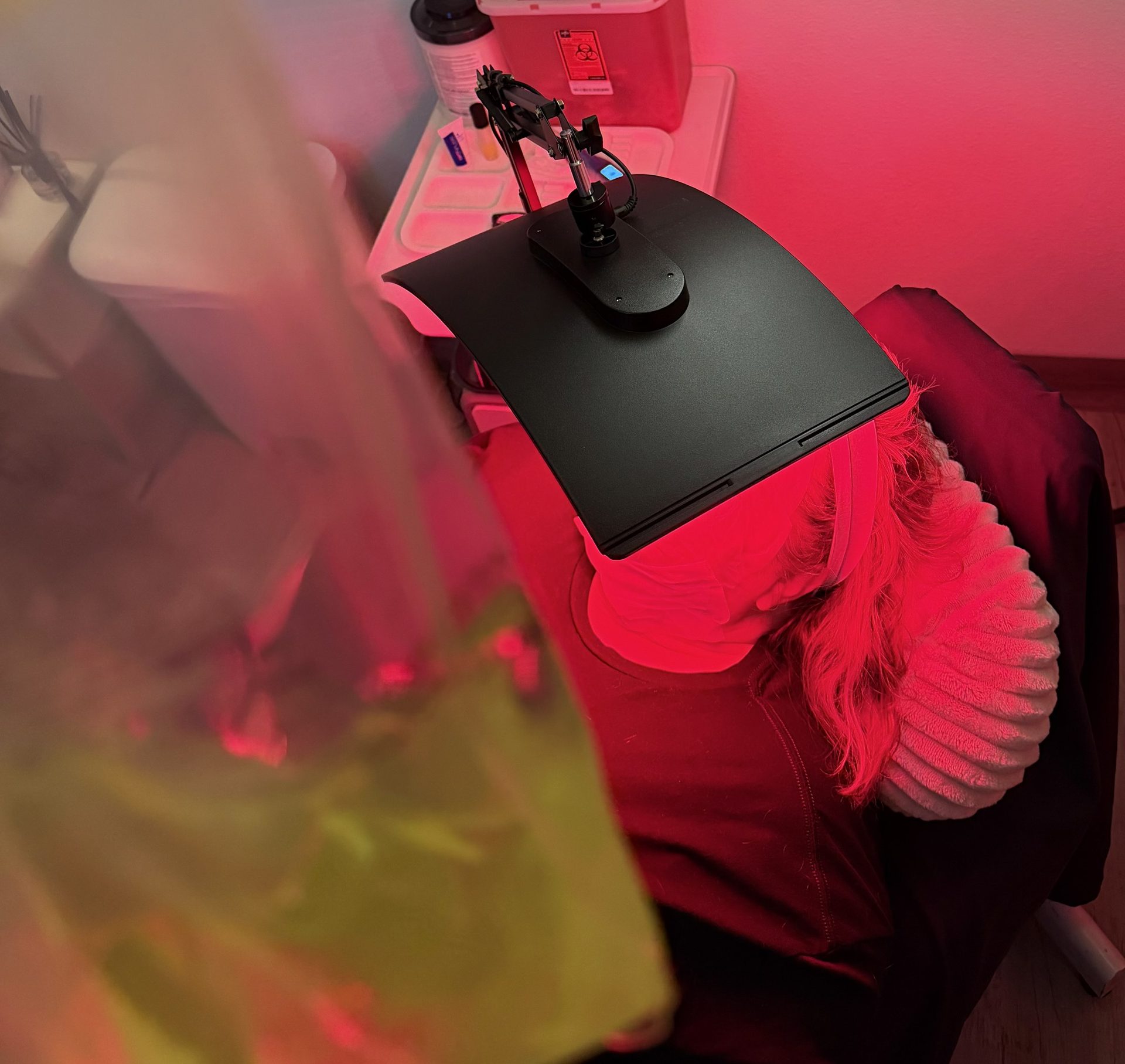 An infusion running under the red light facial lamp