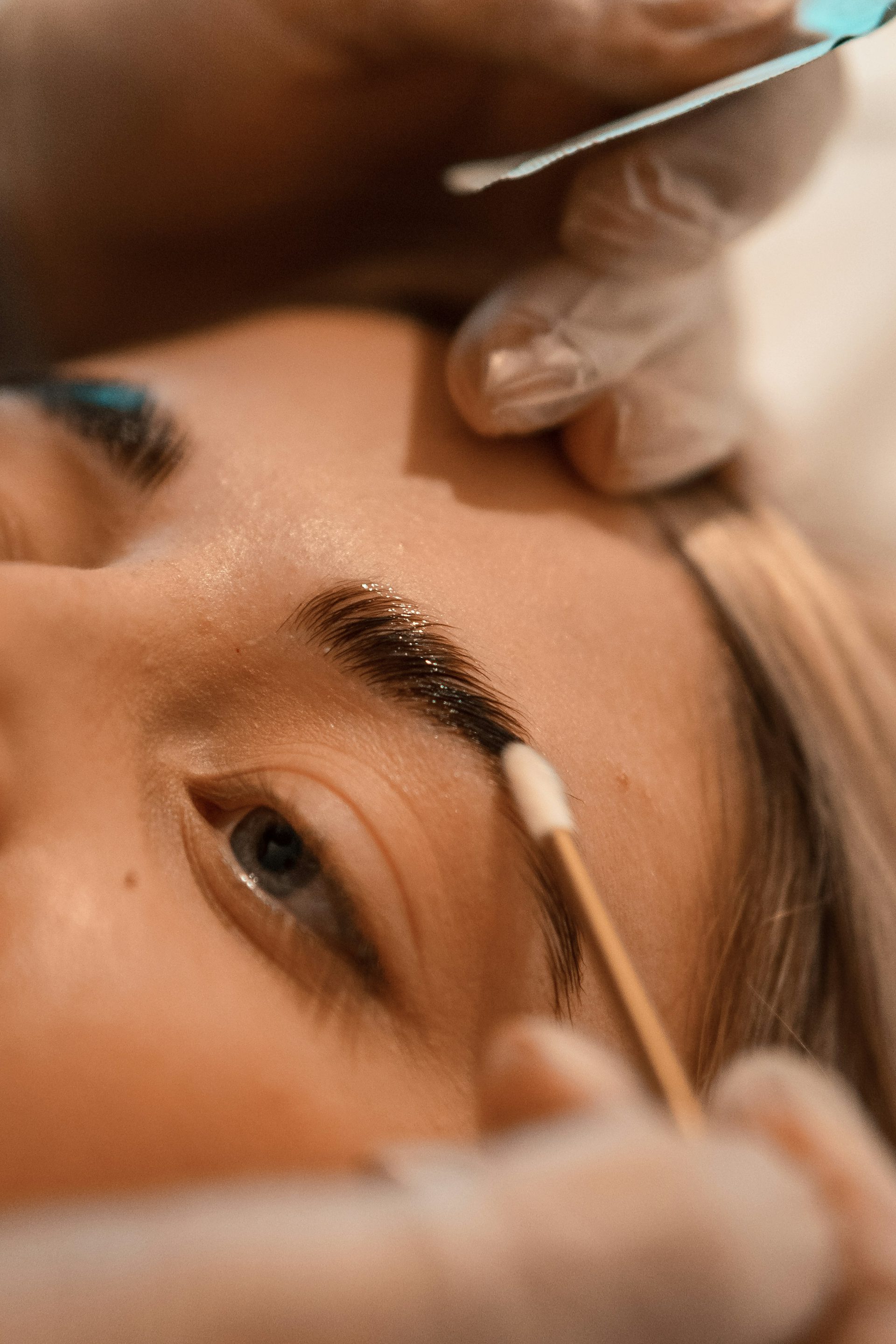 A brow being shaped and brushed