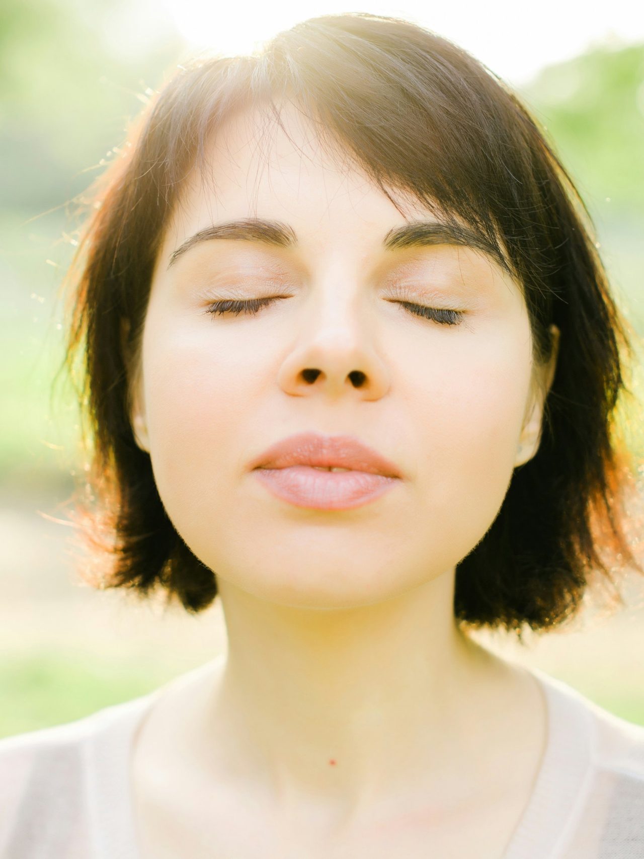 A woman with her eyes closed in the sun