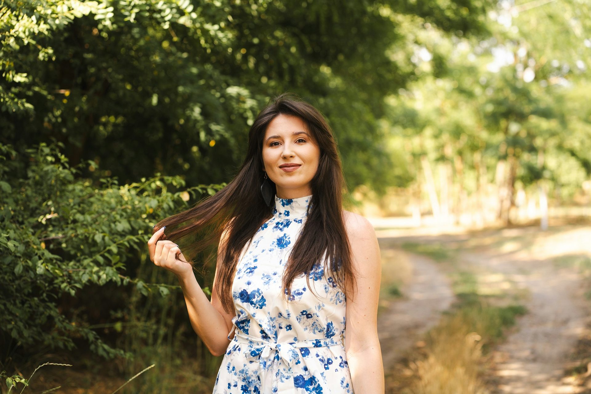 A woman smiling outdoors on a summer afternoon